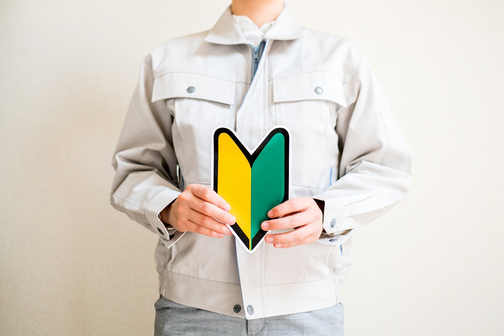 初心者マークを持つ作業服の男性