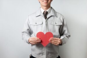 ハートを持つ作業服の男性